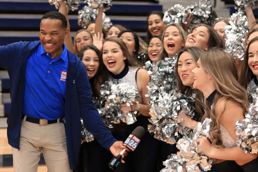 Members of the drill team cheer for the cameras with reporter Nate Griffin.