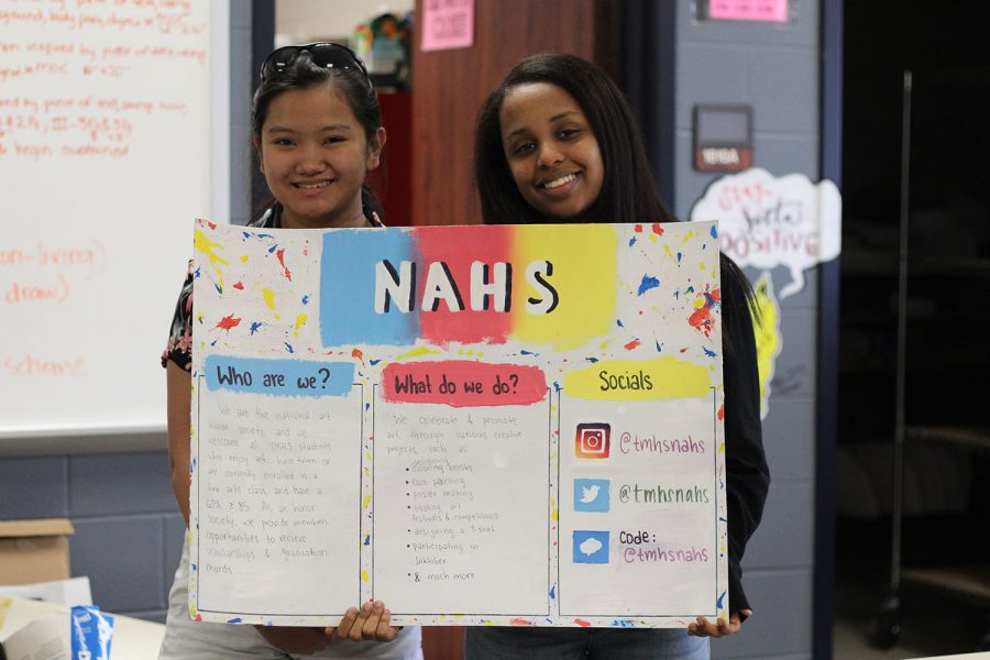 Two members of National Honor Society pose with a poster.
