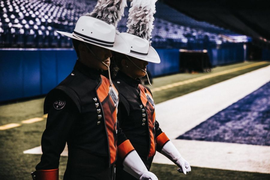 2014 graduate Spencer Holyoak walks into a stadium as drum major for the Crossmen Drum and Bugle Corps.
