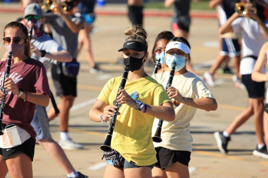 Junior+clarinet+player+Morgan+Larsen+marches+with+a+mask+during+a+rehearsal.