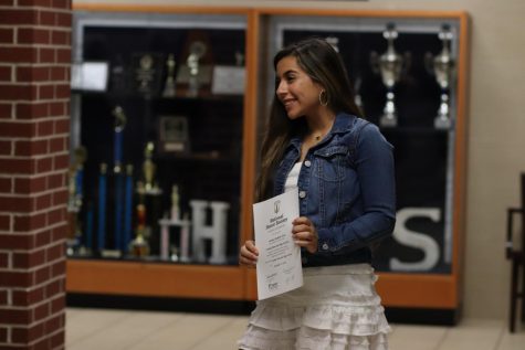A newly inducted NHS member poses after receiving her certificate.