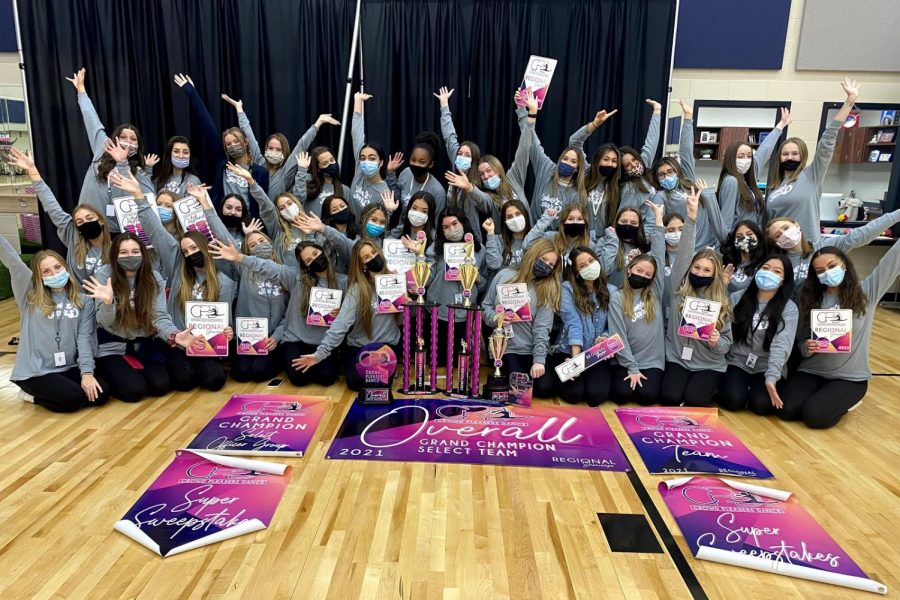 Members of the drill team pose by their awards at Clear Springs High School, where they won overall grand champhion team.