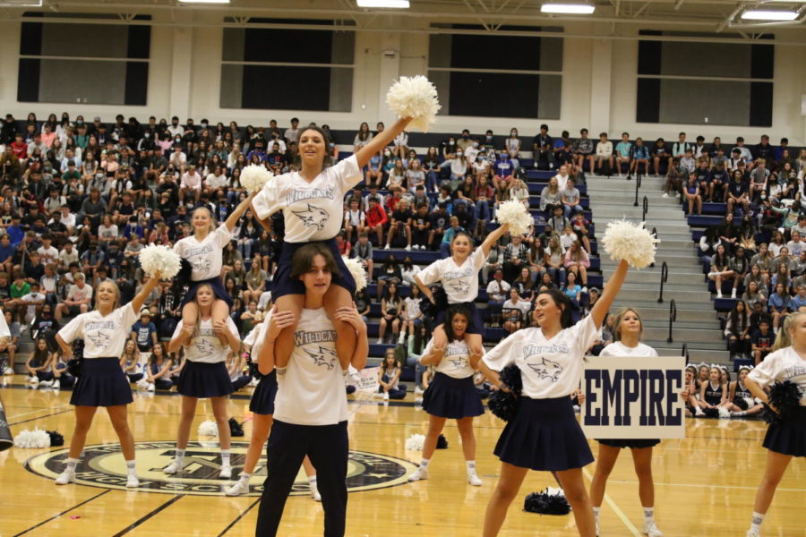 The varsity cheerleaders rally with the crowd to get them hyped for the game.