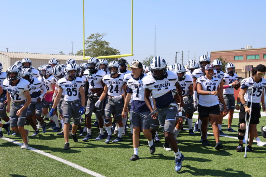 The Wildcats run to the sideline before the start of the game