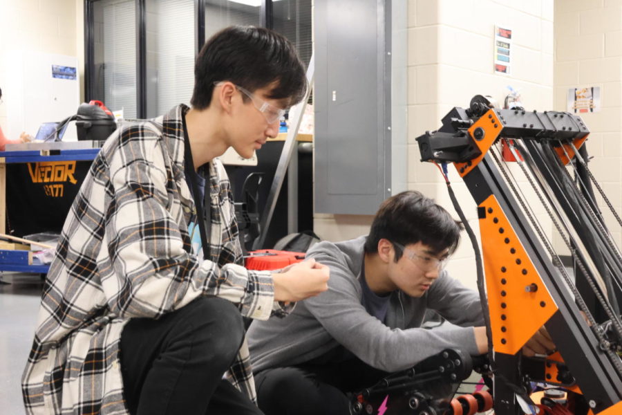Roland Wang (12) and Connor Shen (12) making adjustments to "Velocity"